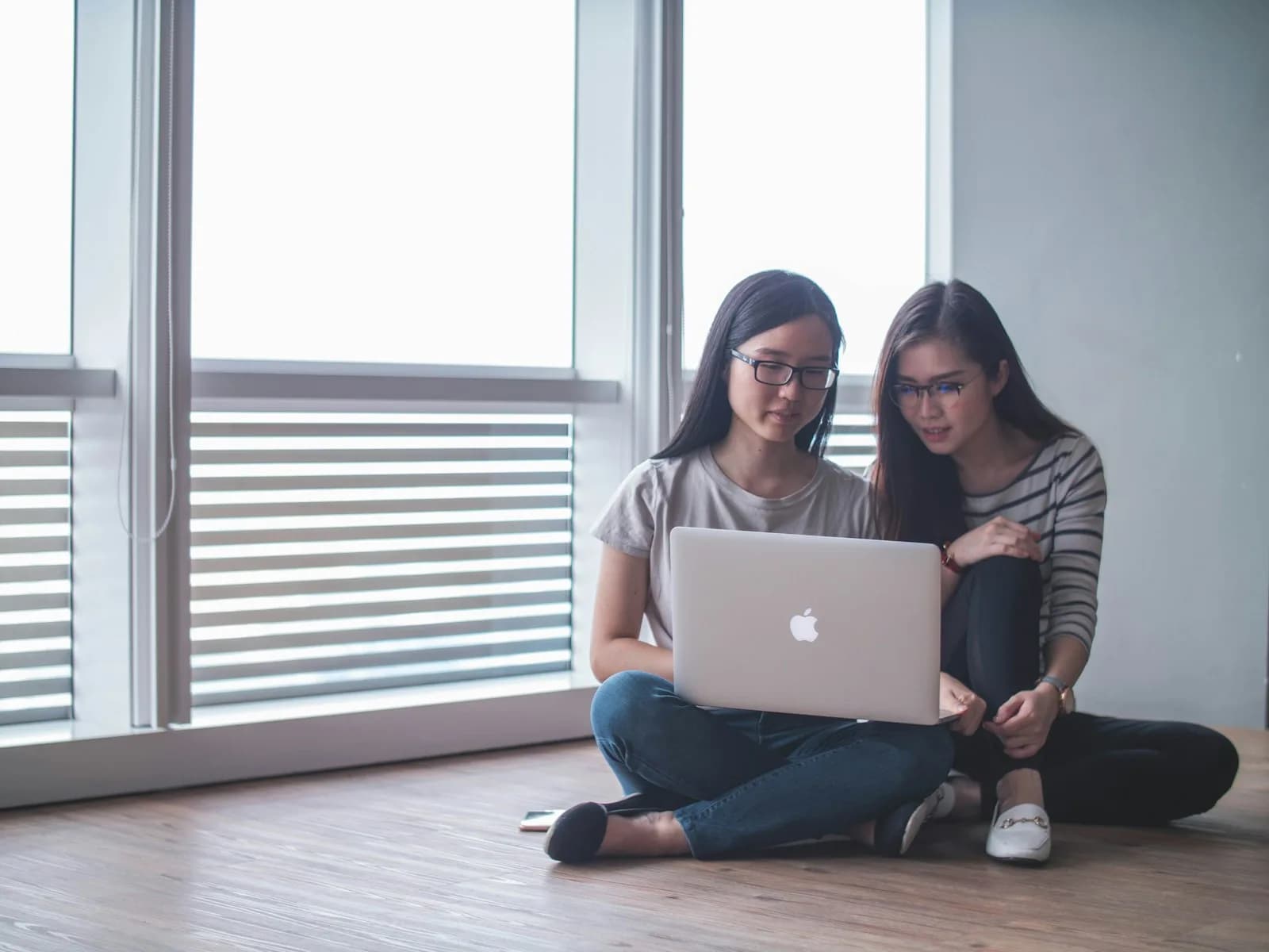 Pelajar Malaysia bekerja yakin dengan laptop di ruang pembelajaran kolaboratif moden dengan elemen AI